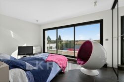Chambre moderne avec fauteuil design.